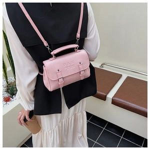 Pink mini backpack with embossed PAN TOR logo shown in a minimalist modern indoor setting