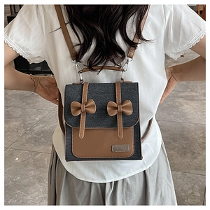 Détail du sac à dos en denim gris avec patchwork en cuir marron et nœuds décoratifs