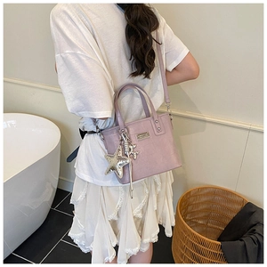 Detail of purple crocodile texture bucket bag with sequin star charm on model