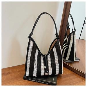 Detailed close-up of mesh knit tote with black and white stripes and leather handle