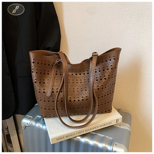 Détails des motifs géométriques découpés au laser sur un sac cabas marron