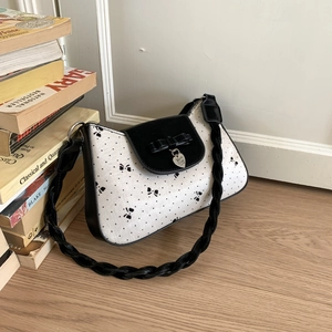 Detail der weiß gepunkteten Tasche mit 3D-Schleife und herzförmigem Silberanhänger