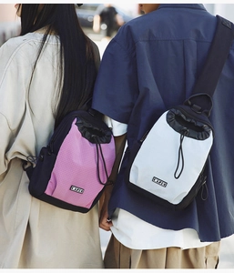 Zwei Personen tragen rosafarbene Karo- und weiße Kordelzug-Brusttaschen beim Wandern