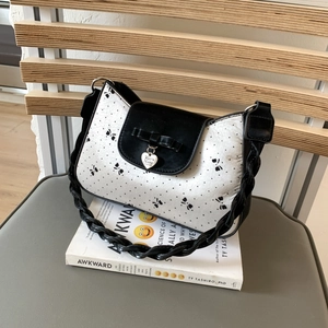 Detailansicht der weißen Stofftasche mit schwarzen Schleifen und Herzanhänger