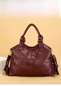 Close-up of deep red tote bag with vintage leather texture and cross stitching details