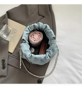 Macro detail of denim bucket bag interior showing space for umbrella and cosmetics