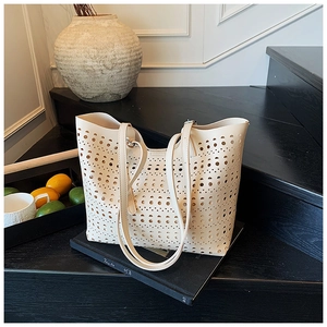 Détail du sac cabas crème ajouré avec motifs géométriques perforés et fines bandoulières