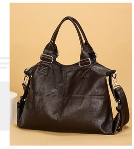 Detail of dark brown pebble leather tote bag featuring silver hardware and crossbody strap
