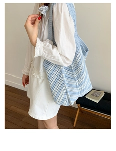 Modella che indossa una borsa tote all'uncinetto a righe bianche e blu