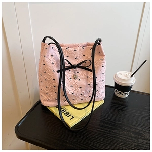 Détail du cabas plissé rose avec nœuds noirs et pendentif en forme de cœur en métal