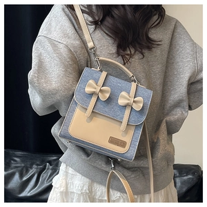 Detail of vintage denim patchwork crossbody bag with 3D bows shown on model