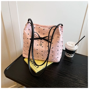 Gros plan du sac rose avec nœuds noirs, pendentif cœur et texture en relief