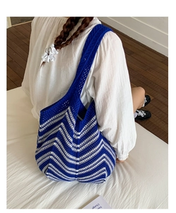 Dettaglio della borsa shopper all'uncinetto blu e bianca con motivo a onde in maglia