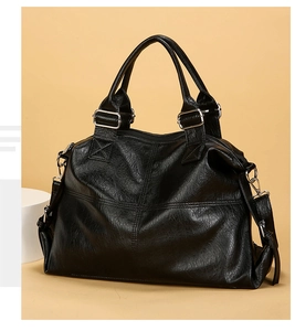 Detailed macro view of black lychee grain leather handbag with silver hardware and stitching