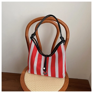 Detail of red and white striped mesh hobo bag with knotted black strap and metal ring