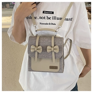 Détails du mini sac à dos en tweed et cuir beige avec nœuds porté par un mannequin
