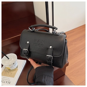 Close-up of black retro lychee texture small square bag with PAN TOR embossed logo