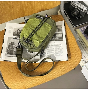 Close-up of olive green crossbody bag with ripstop texture and drawstring closure detail
