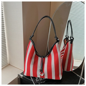 Detail of red and white striped knit tote bag with black strap and crescent moon pendant