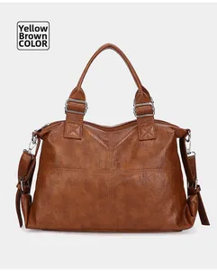 Detail view of yellow brown leather tote bag with silver hardware and cross stitching