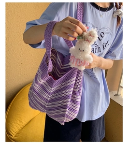 Dettaglio della trama a maglia della borsa tote a righe viola con ciondolo a coniglio