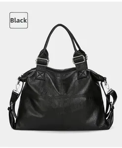 Detail of black large capacity tote bag featuring textured leather and silver hardware