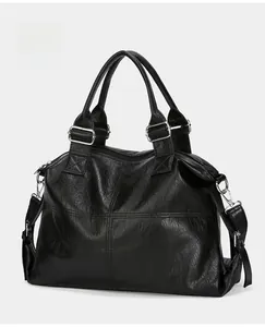 Close-up of black lychee-grain faux leather tote bag with sturdy handles and metal hooks