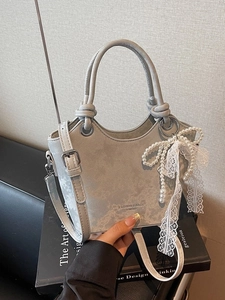 Sac seau gris élégant avec breloque nœud en dentelle perlée et détails argentés