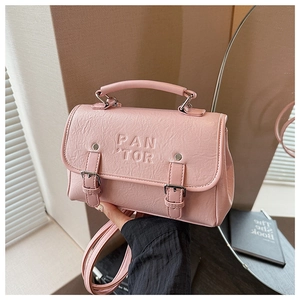 Detailed view of pink PU leather crossbody bag with silver buckles and hand strap