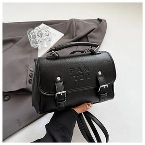 Close-up of black lychee grain PU leather texture and PAN TOR embossed logo on bag