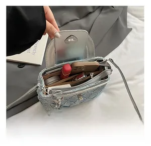 Interior view of small denim crossbody bag showing multi-compartment storage and silver lining