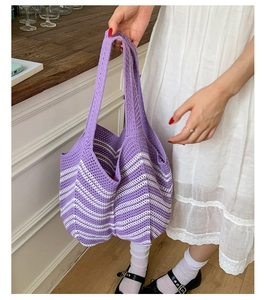 Dettaglio della borsa tote in maglia a righe viola e bianche con trama bohémien