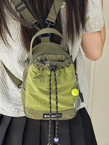 Olive green drawstring backpack with bright green check pattern and tennis charm