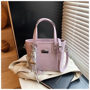 Detail of lavender crocodile texture bucket bag with star charm in soft natural light