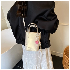 Détail du sac seau champagne avec pendentif cœur rose et foulard en soie décoratif