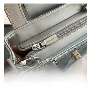 Close-up of light blue quilted denim texture with elegant silver metal hardware and zipper