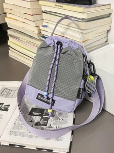 Lilac purple drawstring bucket crossbody bag with a checkered pattern and tennis charm