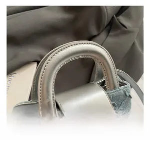 Detail of blue denim handbag with ruffled texture and silver heart-shaped metal lock