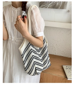 Dettaglio della borsa tote in maglia intrecciata a mano con strisce ondulate bianche e nere