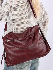 Classic burgundy large tote bag in oil-wax faux leather worn by model on shoulder