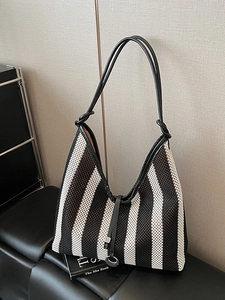 Minimalist striped woven tote bag with slim black leather straps for summer commute