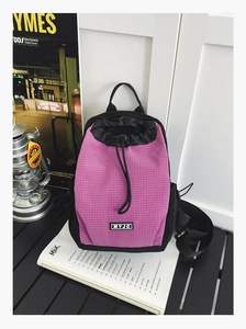 Detail eines rosa karierten Nylon-Kordelzug-Rucksacks auf einem Campingtisch mit Zubehör