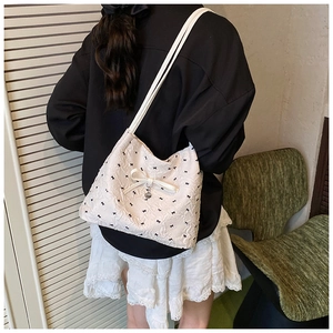 Détail d'un sac cabas blanc avec imprimé nœud noir et texture de tissu 3D gaufré