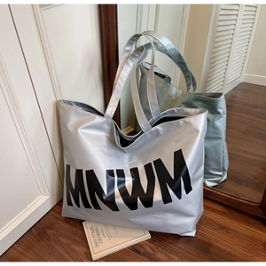 Detail of silver tote bag with MNWM lettering and large capacity interior space