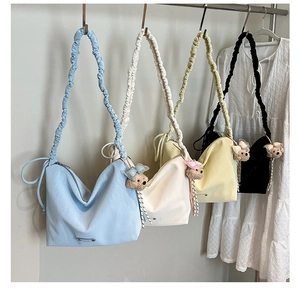 Detail of four colorful tote bags with pleated straps and cute bear plush charms