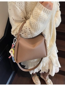 Sac seau en cuir marron à grain lychee avec charme arc-en-ciel en situation réelle