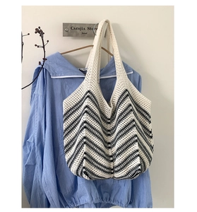 Dettaglio della borsa tote tessuta con motivo a onde bianco e nero e maglia fitta