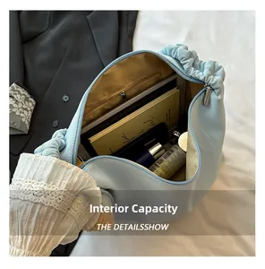Interior detail of large capacity light blue cloud bag showing storage for books and cosmetics