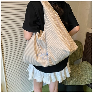 Detail of large capacity striped tote bag with Our Joy Party embroidery on the side