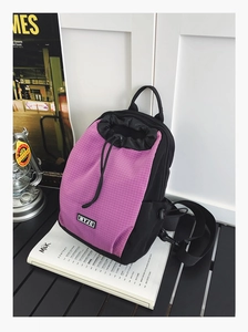 Wasserdichter schwarzer Mini-Rucksack mit lila Karomuster und MYJC-Logo auf Holztisch